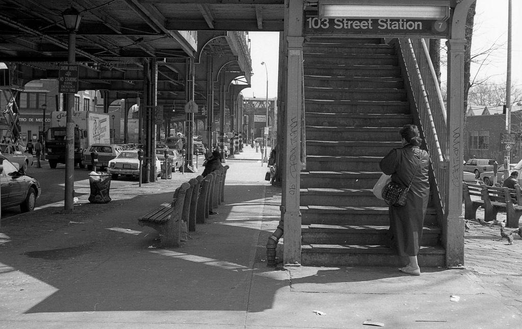 A commuter walking up the staircase to the elevated subway on Roosevelt Avenue (at 103rd Street), in the Corona neighborhood. Queens, New York, 1990.