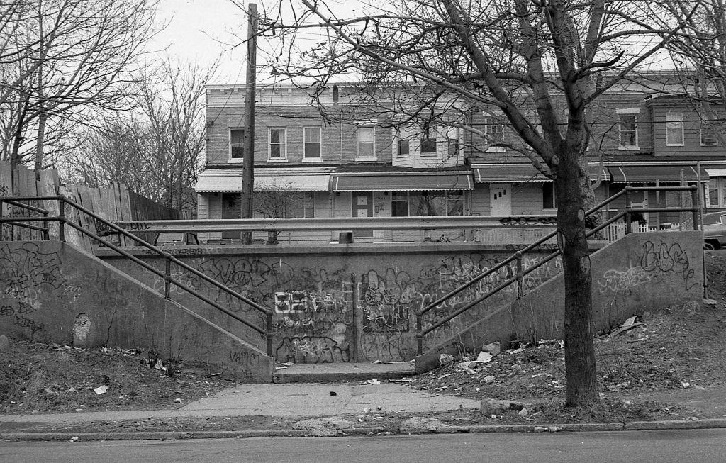 Dilapidated and graffiti-covered cement staircases that lead to a row of residential homes on 37th Avenue (near 110th Street) in Corona. Queens, New York, 1982.