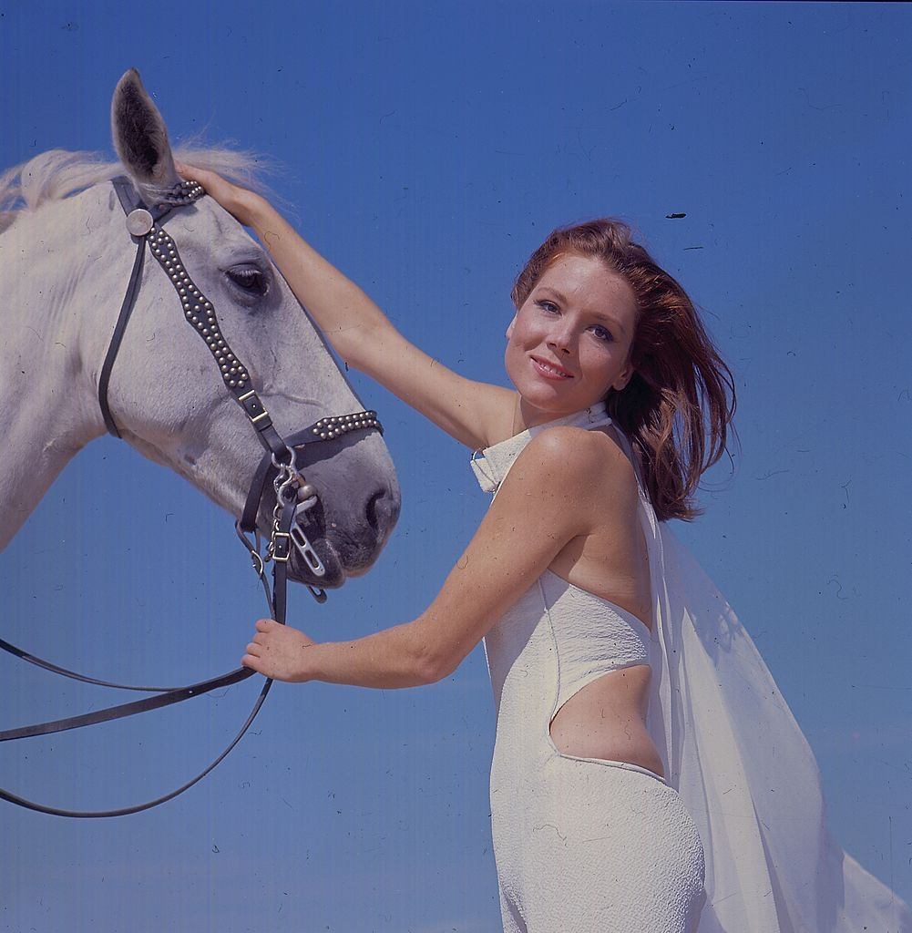 Diana Rigg with a white horse on Camber Sands, 1967.