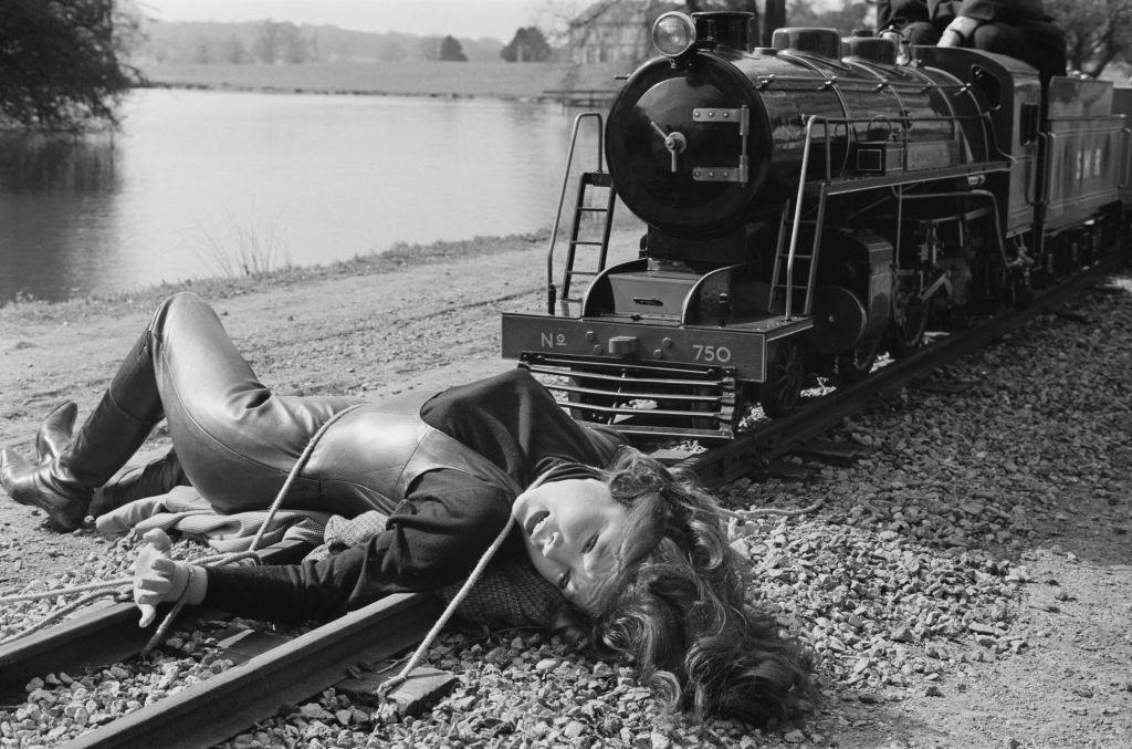 Diana Rigg tied to the rail of a train filming a scene of television series 'The Avengers', 4th April 1965.