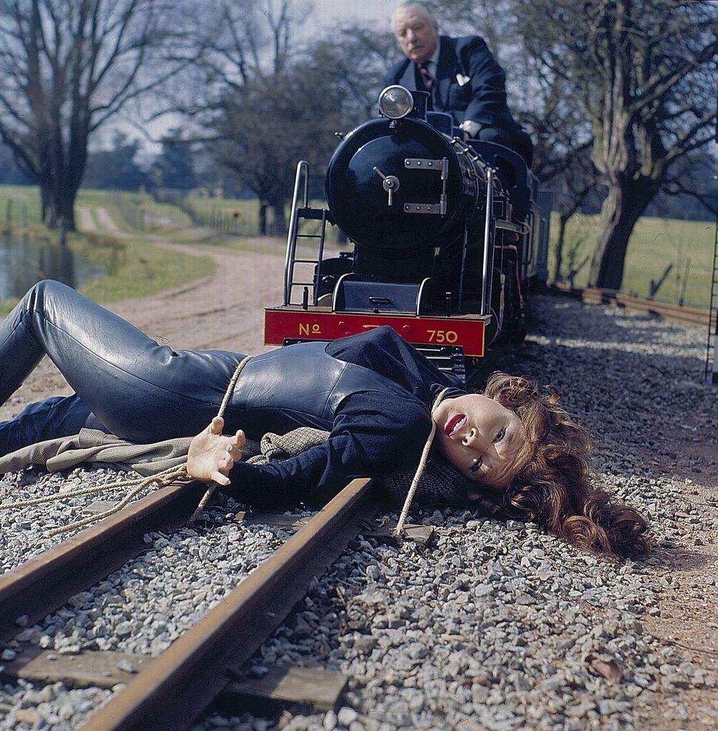 Diana Rigg as 'Emma Peel' is tied to a railway track as a miniature train advances on her in a scene from the television series 'The Avengers' in 1968.