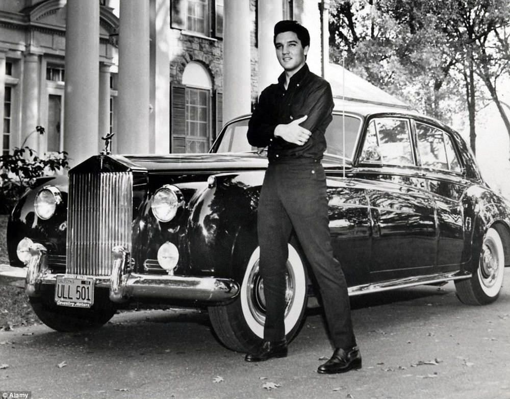 Elvis with his Phantom Rolls Royces, which he bought in 1961, outside his Graceland mansion.