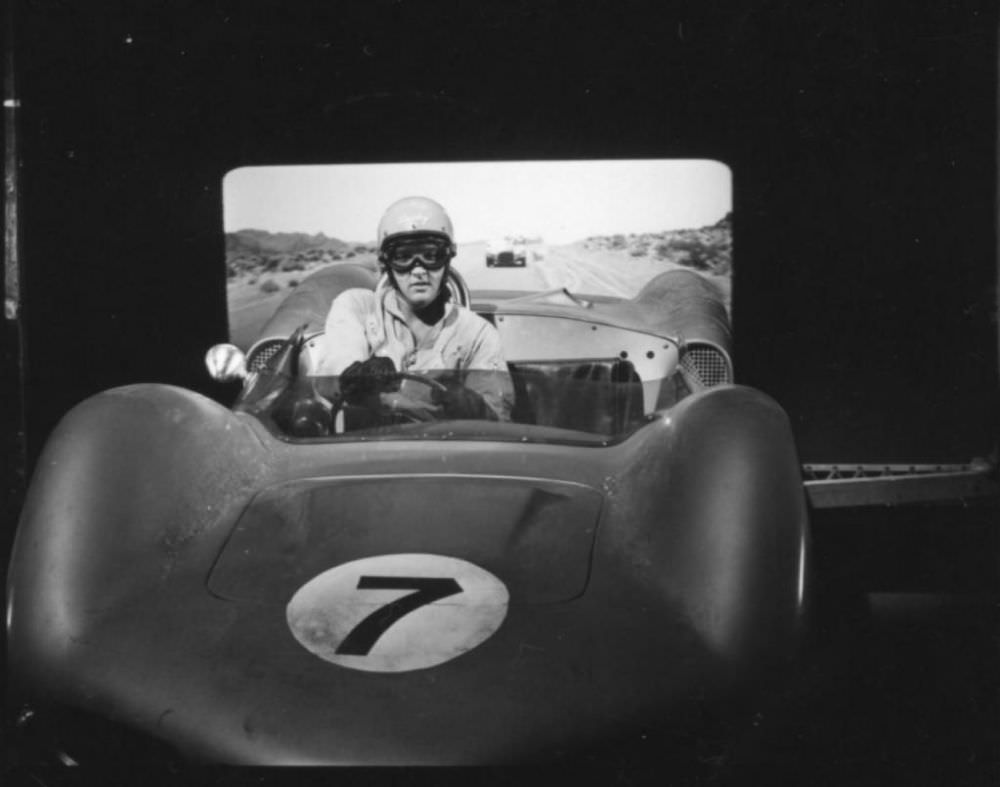 Elvis behind the wheel of a 1962 Elva Mk. VI with a video backdrop comes from the filming of 1964’s Viva Las Vegas.