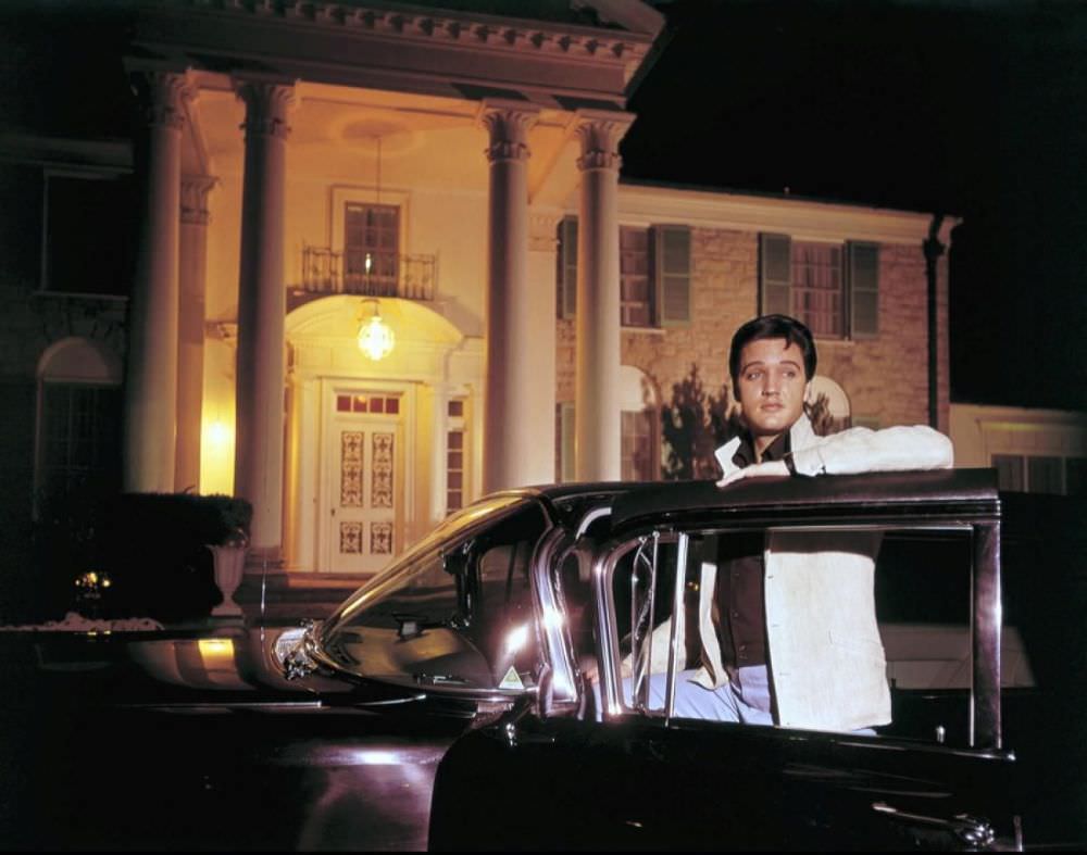 Elvis poses with one of his cars outside of Graceland, his mansion in Memphis, Tenn.
