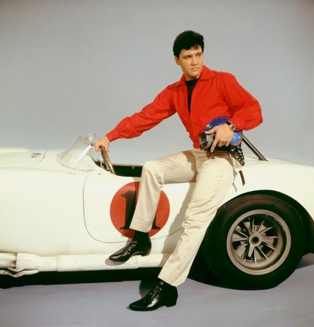 Elvis poses in the press shot for 1966 film Spinout with a 1966 AC Cobra 427.