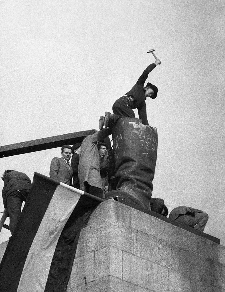 Revolutionaries breaking up a Statue of Stalin.