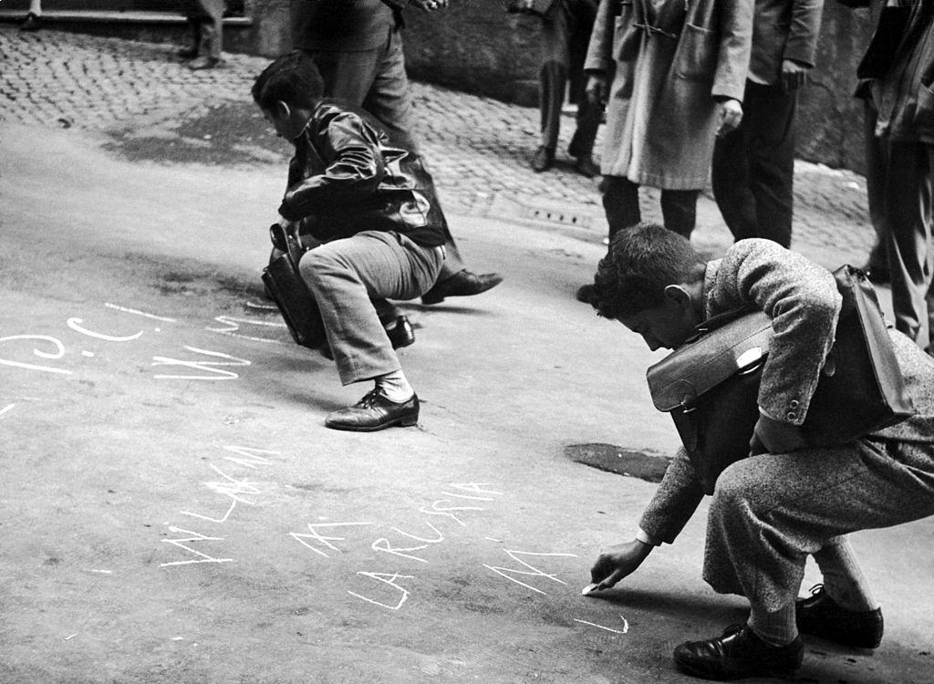 Students writing on the ground some solidarity messages to the rebels in Hunary after the repression by Soviet Tanks, 1956.