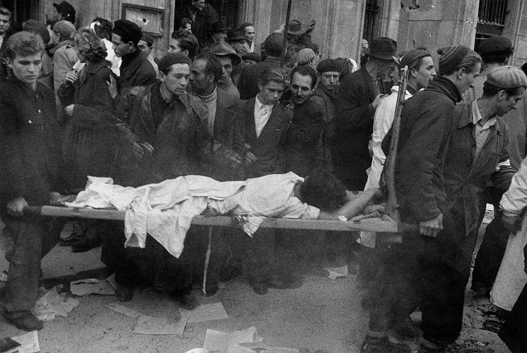 An Hungarian insurgent wounded in the battle for the headquarters of the Communist Party is carried on a stretcher during the revolt. Budapest, November 1956