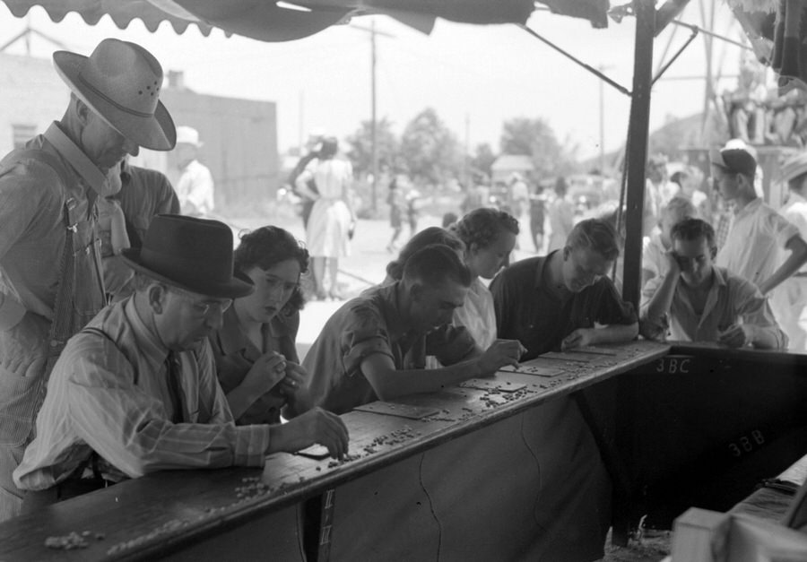 Carnival rides in the background, Bingo players in foreground, Vale, Oregon, July 4, 1941.