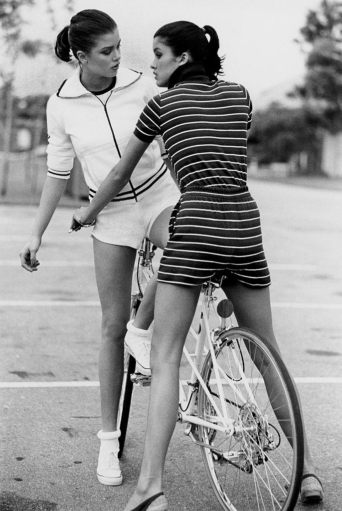 Janice Dickinson with her sister Deborah traddling a bicycle at the Boca West Resort, in Florida, 1977