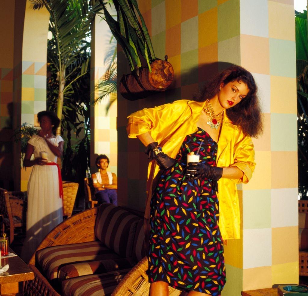 Janice Dickinson wearing a colorful print cocktail dress with a yellow satin jacket, 1979.
