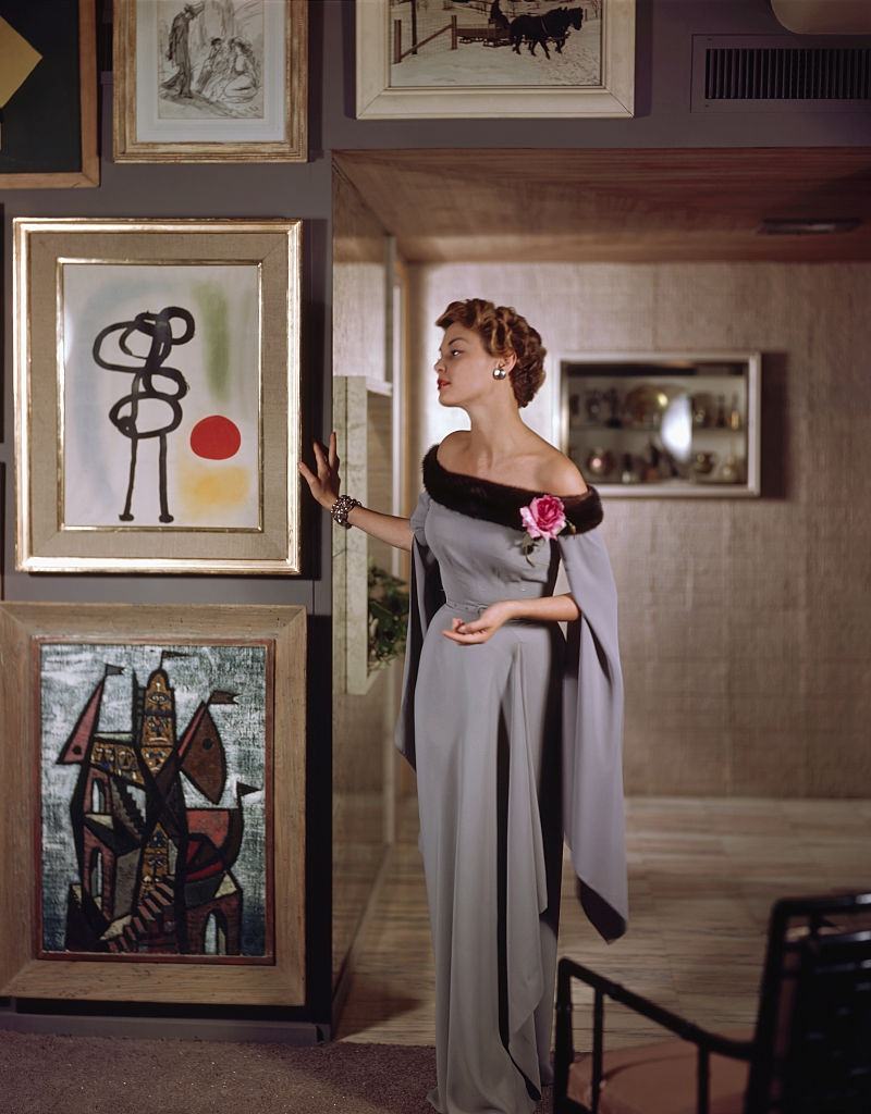 Jean Pachett models a dress by Netti Rosenstein in the art-filled apartment of Raymond Loewy, 1950.