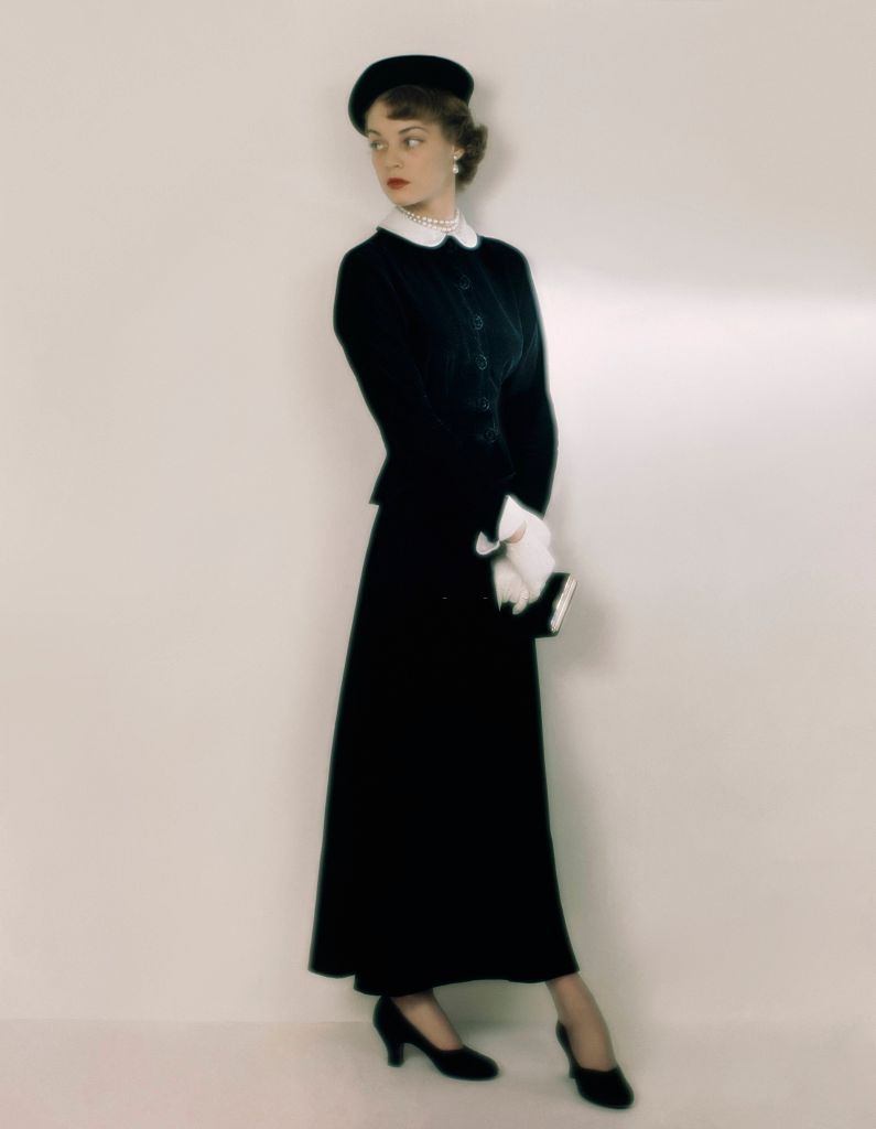 Jean Patchett in a slender-skirted theatre suit in black taffeta and black velvet, 1948.