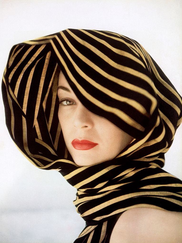 Jean Patchett sheltered with a rebozo of black and gold stripes. Vogue 1951
