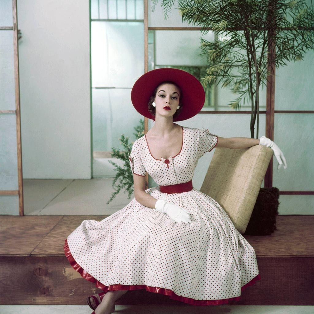 Jean Patchett in red and white polka dot dress with petticoat ruffle, hat and gloves, 1952.