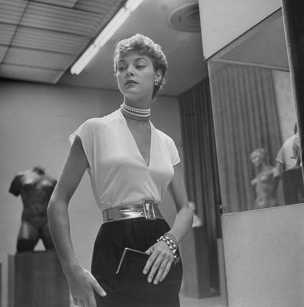 Jean Patchett wearing jewelry, setting off a classic blouse of white rayon jersey, 1949.