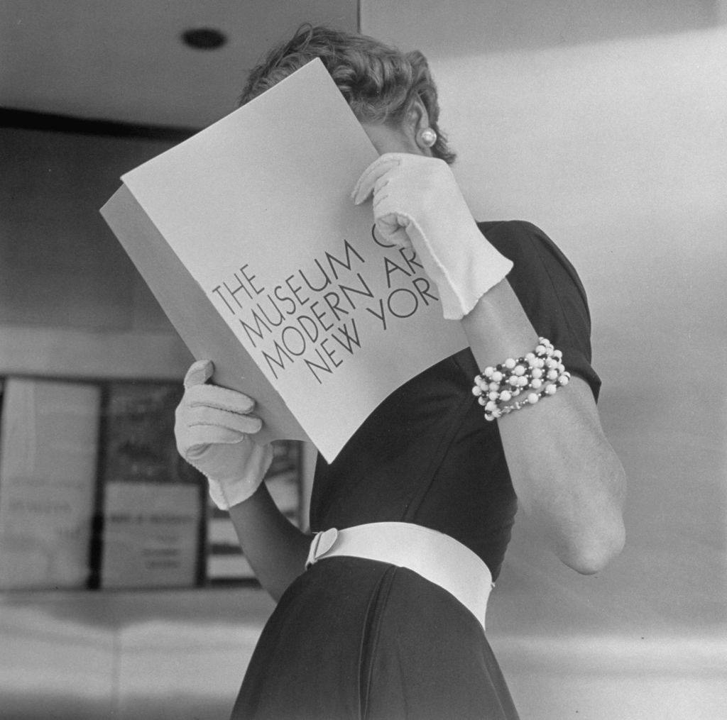 Jean Patchett wearing white touches that set off expensive black dress, 1949.