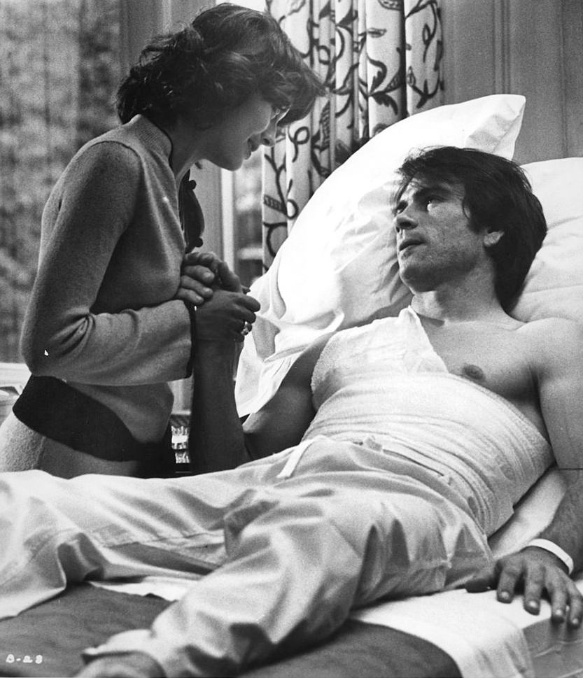 Lesley-Anne Down comforts injured Tommy Lee Jones bedside in a scene from the film 'The Betsy', 1978.