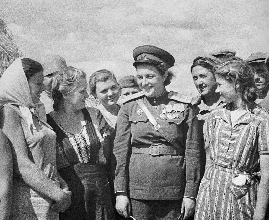 Lyudmila Pavlichenk surrounded by Volny Burlak kolkhoz workers during World War II.