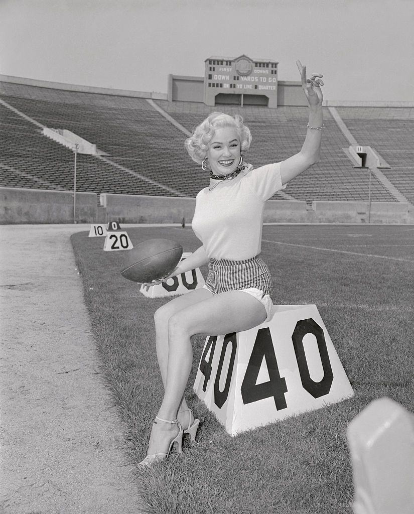 Mamie Van Doren Posing on Football Marker on the filed. She played an important supporting role to Tony Curtis and Joanne Dru in Universal International's Forbidden.