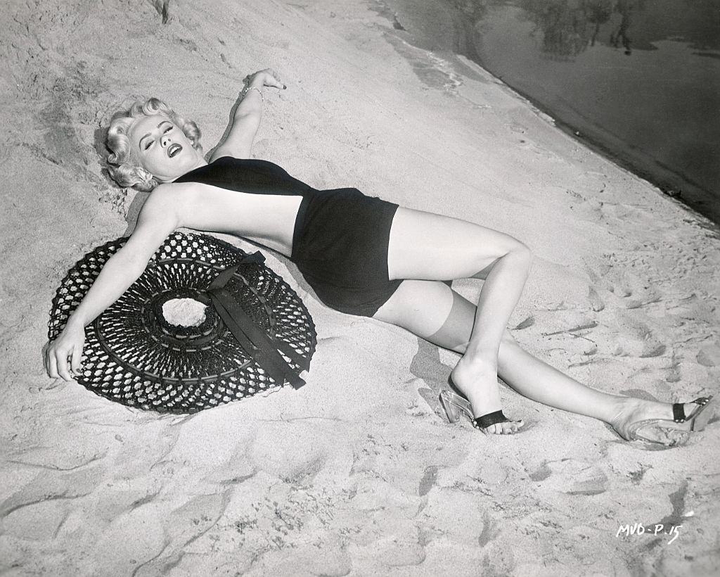 Mamie Van Dore in black dress on the beach, 1953.