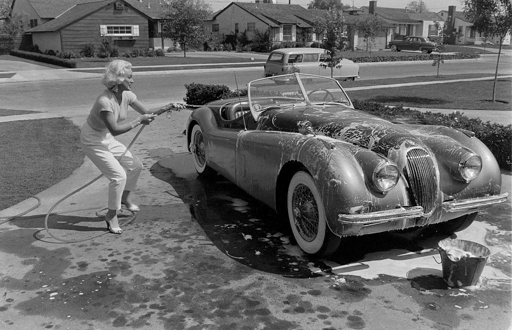 Mamie Van Doren washing her Jaguar XK140 OTS sportscar, 1954.