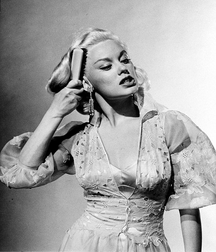 Mamie Van Doren brushing her hair in anger during acting exercise, 1954.