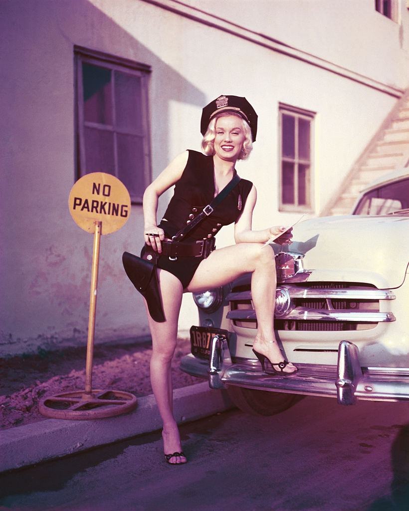 Mamie Van Doren posing with no parking sign, 1954.
