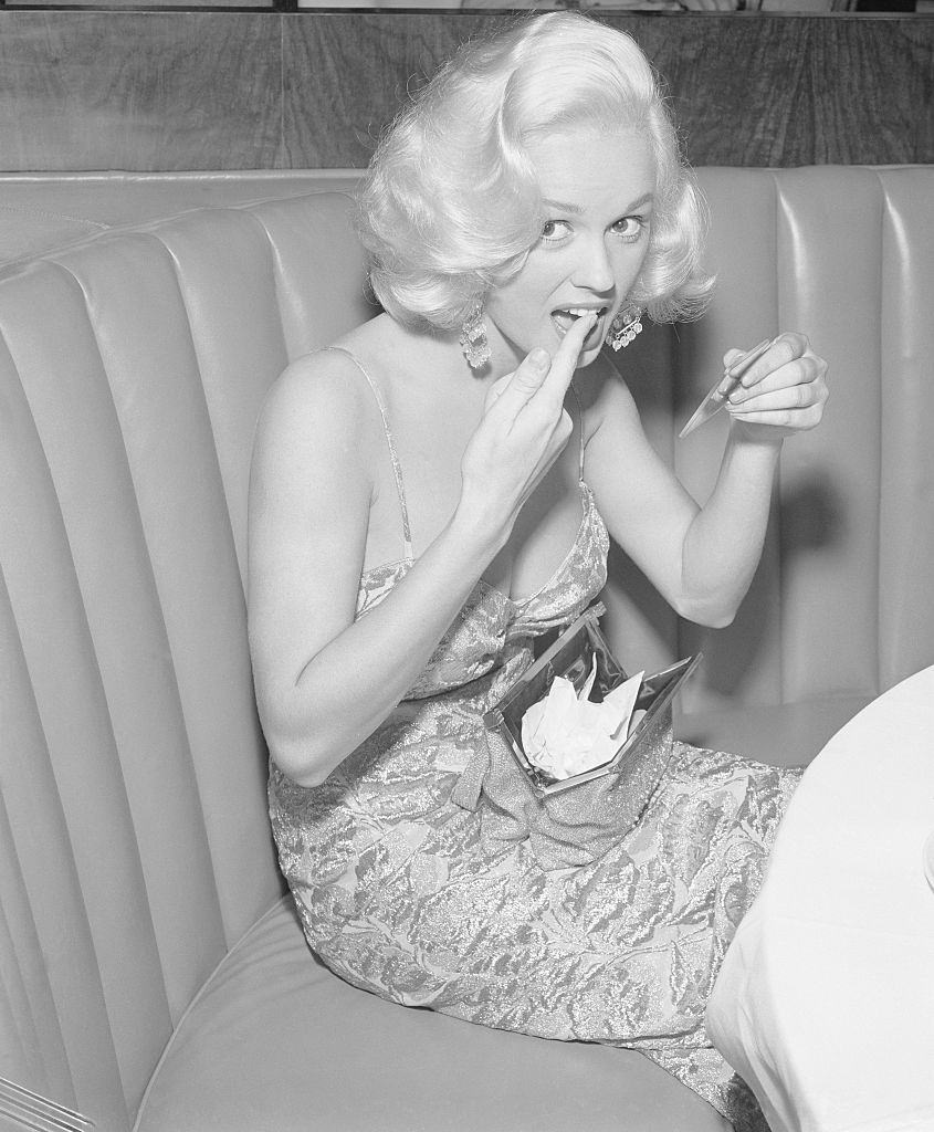 Mamie Van Doren must check her makeup after dinner, 1955.