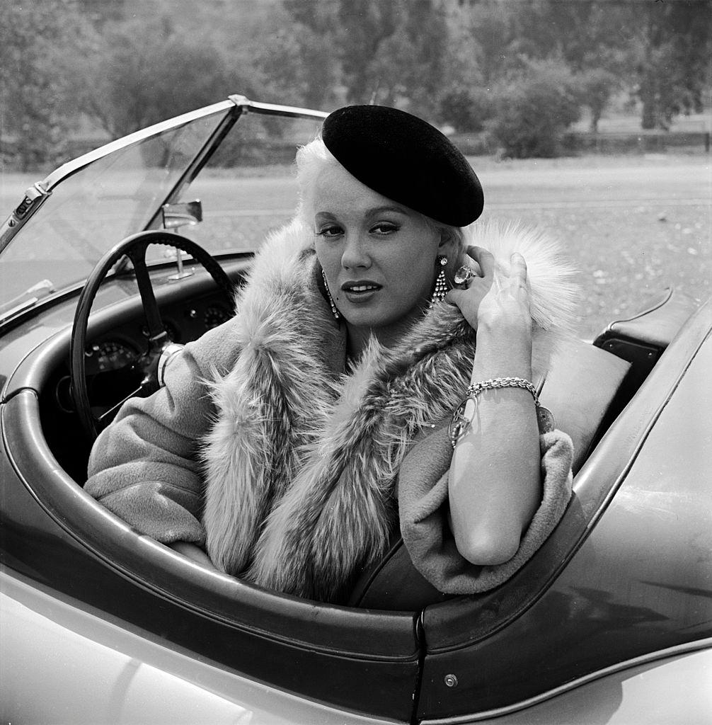 Mamie Van Doren sitting in her Jaguar, 1955.