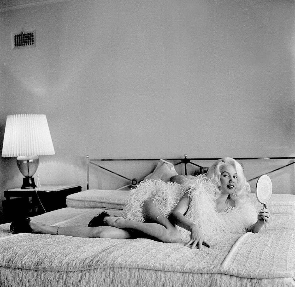 Mamie Van Doren lying on the bed in her home at Los Angeles, 1956.