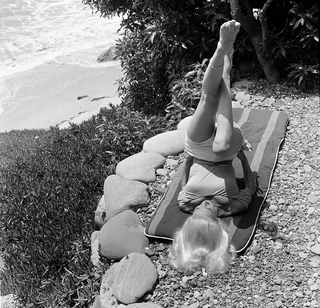 Mamie Van Doren exercising at the beach, 1956.