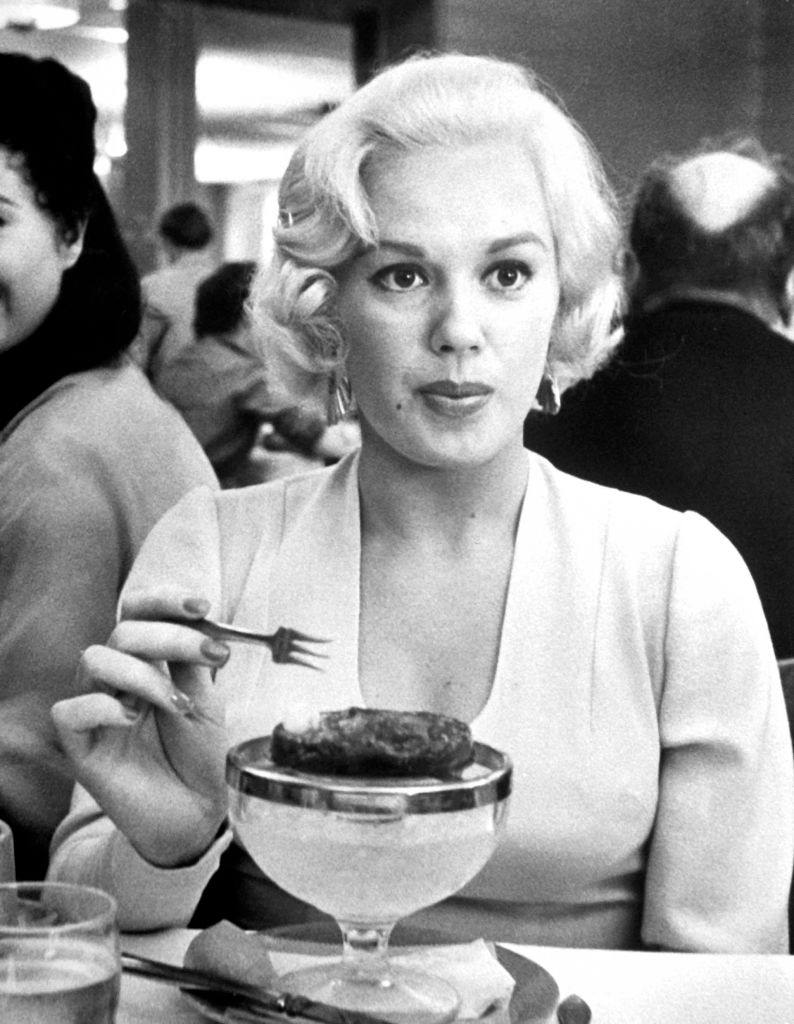 Mamie Van Doren eating a frozen dessert at Universal Studios commissary, 1955.