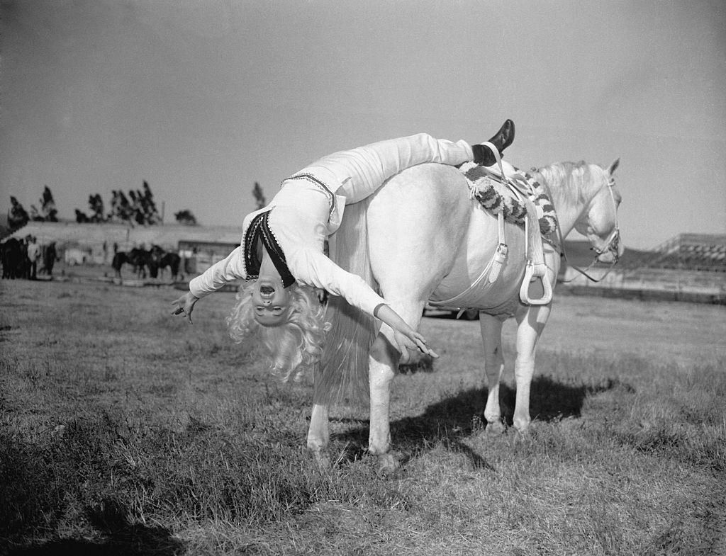 Mamie Van Doren Hanging off Rear of Horse, 1957.