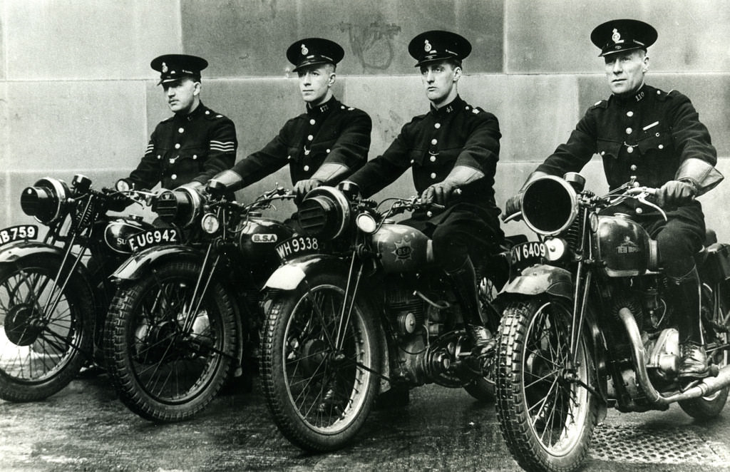 Four officers of Bolton Borough Police sit astride their motorcycles
