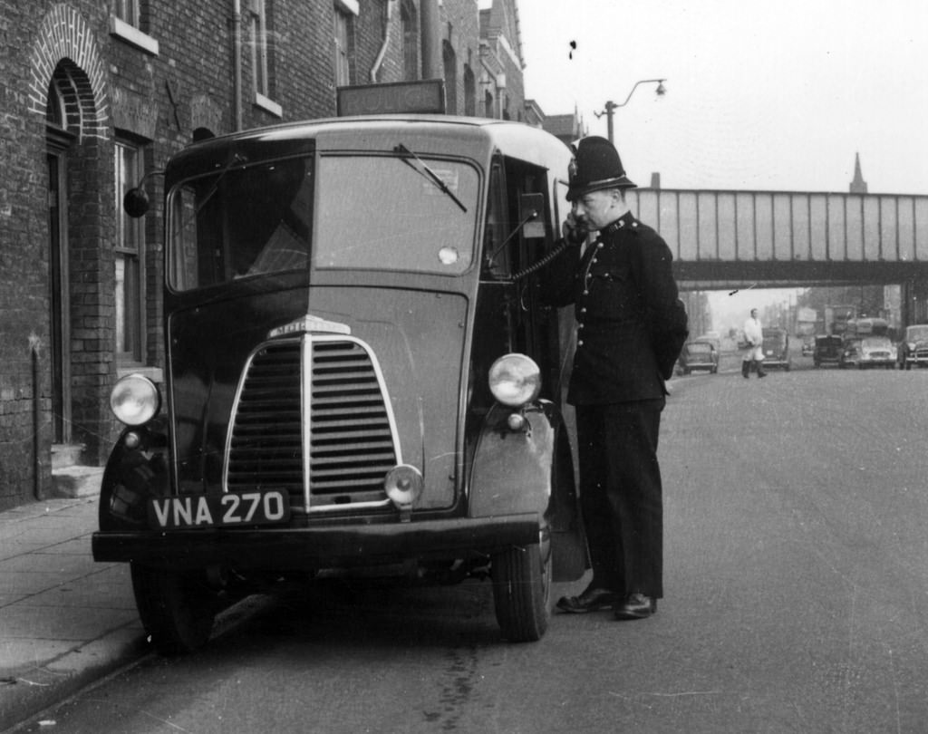 An officer of Manchester City Police uses the radio fitted to his Morris J -Type van in the late 1950s