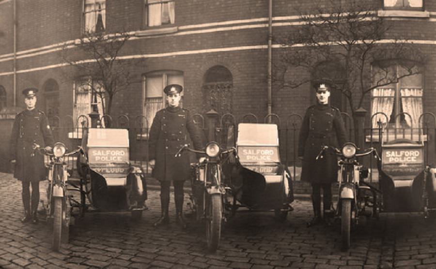 Officers of Salford City Police pose proudly with their sidecars on a cobbled street, 1920s
