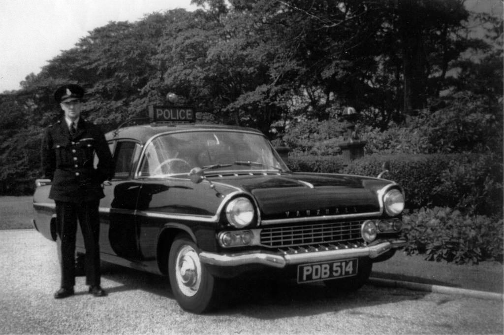 An officer of Stockport Borough Police stands proudly besides his Vauxhall Velox vehicle in Stockport's Woodbank Memorial Park , 1962