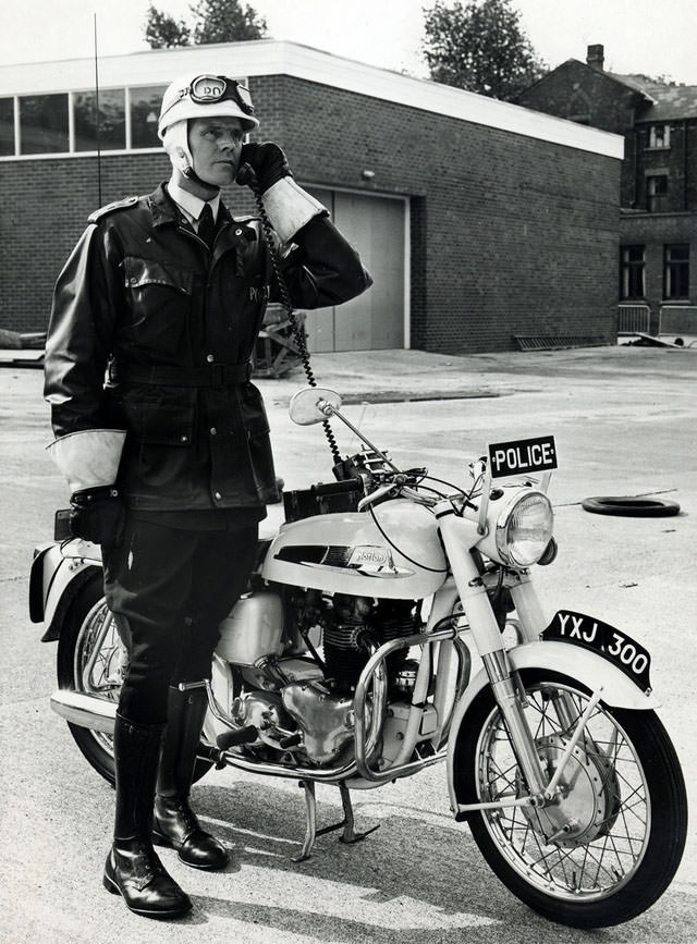 An officer of Manchester City Police test the radio on his Norton Atlas police motorcycle in the yard of Longsight Police Station prior to going out on patrol, 1963