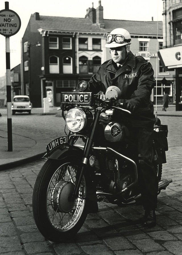 An officer of Bolton Borough Police sits astride his BSA motorcycle in central Bolton, 1964.