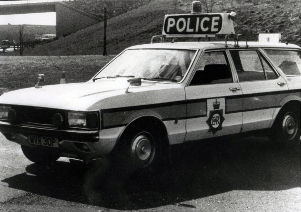 A Ford Granada of Greater Manchester Police's Motorway Unit sits beside the carriageway in the mid to late 1970s