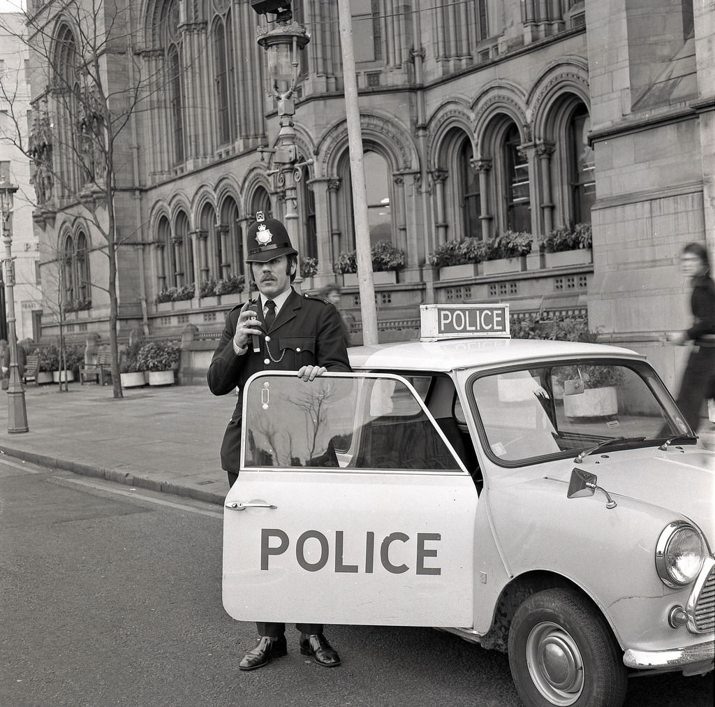 A Greater Manchester Police officer parks his Mini outside the famous Manchester Town Hall in 1974