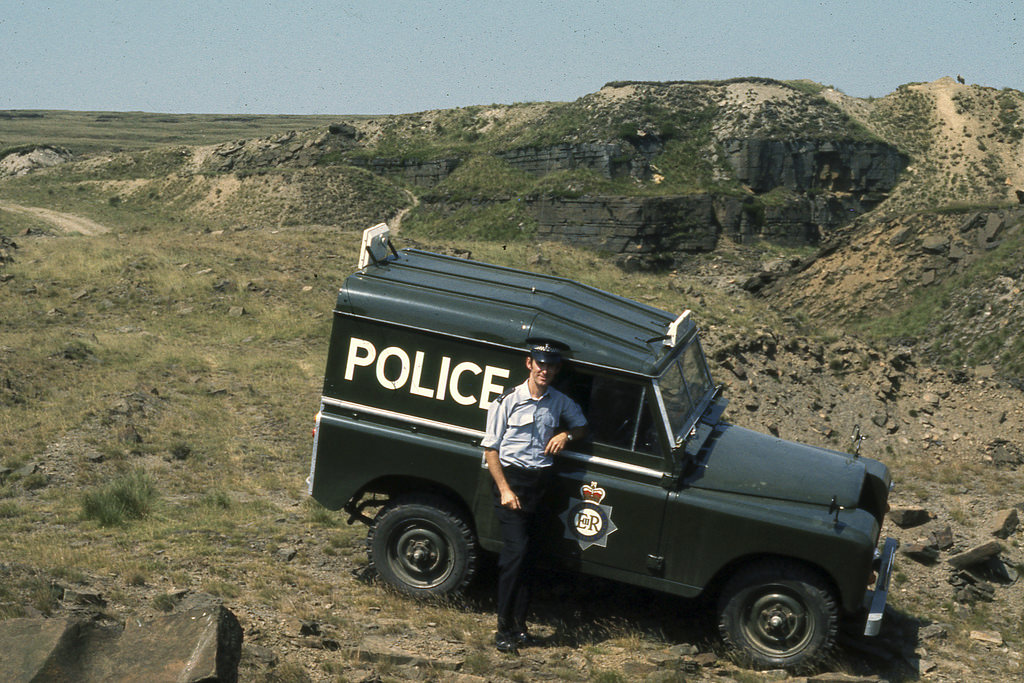 A police officer stands beside one of Greater Manchester Police's Land Rovers on 1 July 1976