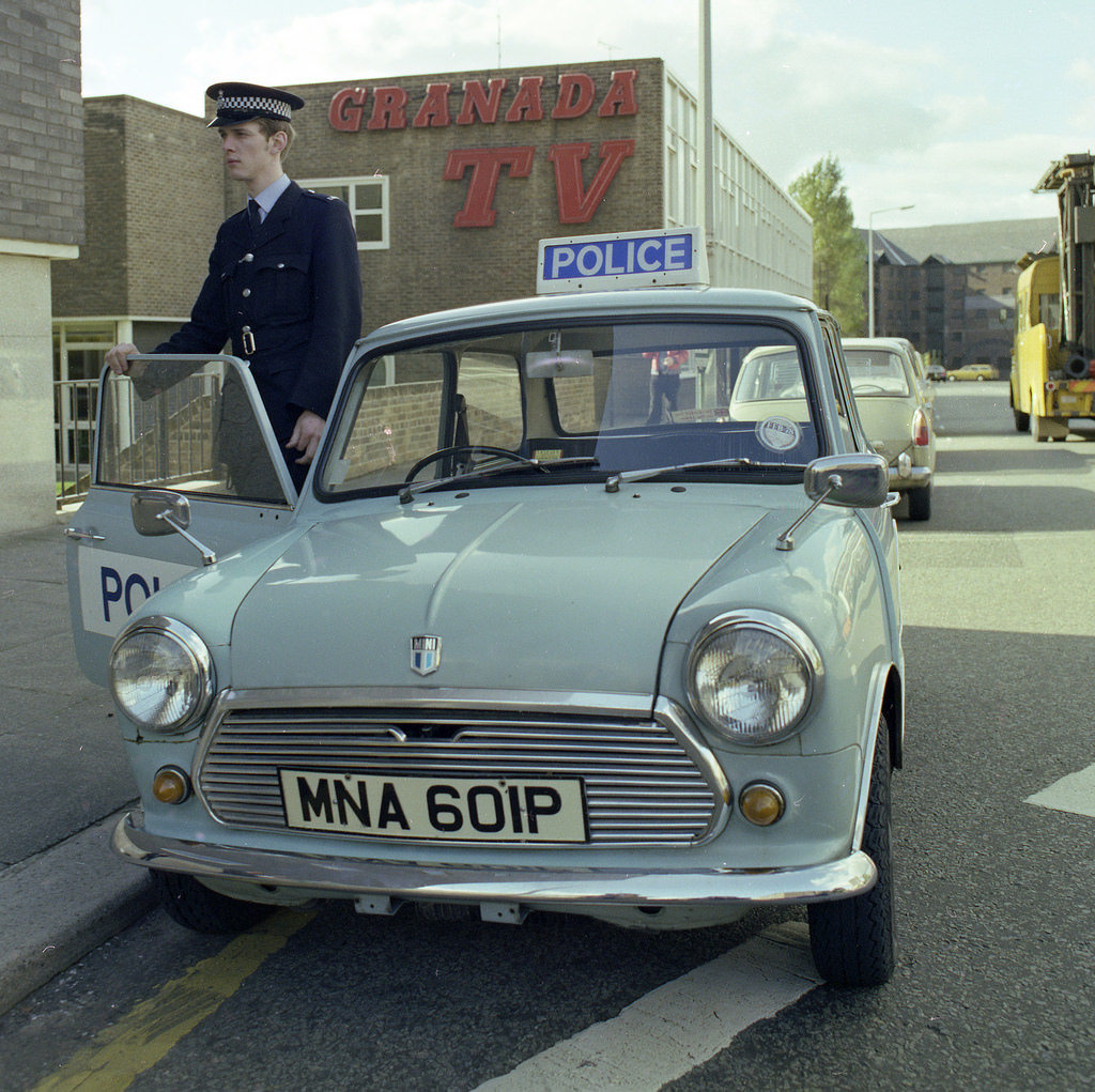 A Greater Manchester Police officer and his Mini patrol car outside part the Granada Television complex on Quay Street in Manchester, 1977