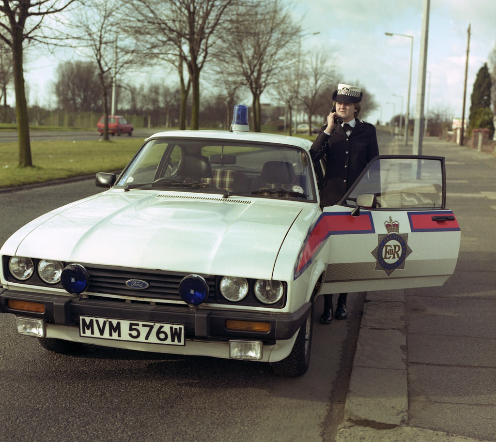 A Greater Manchester Police officer and her Ford Capri vehicle in Chorlton-cum-Hardy in 1982