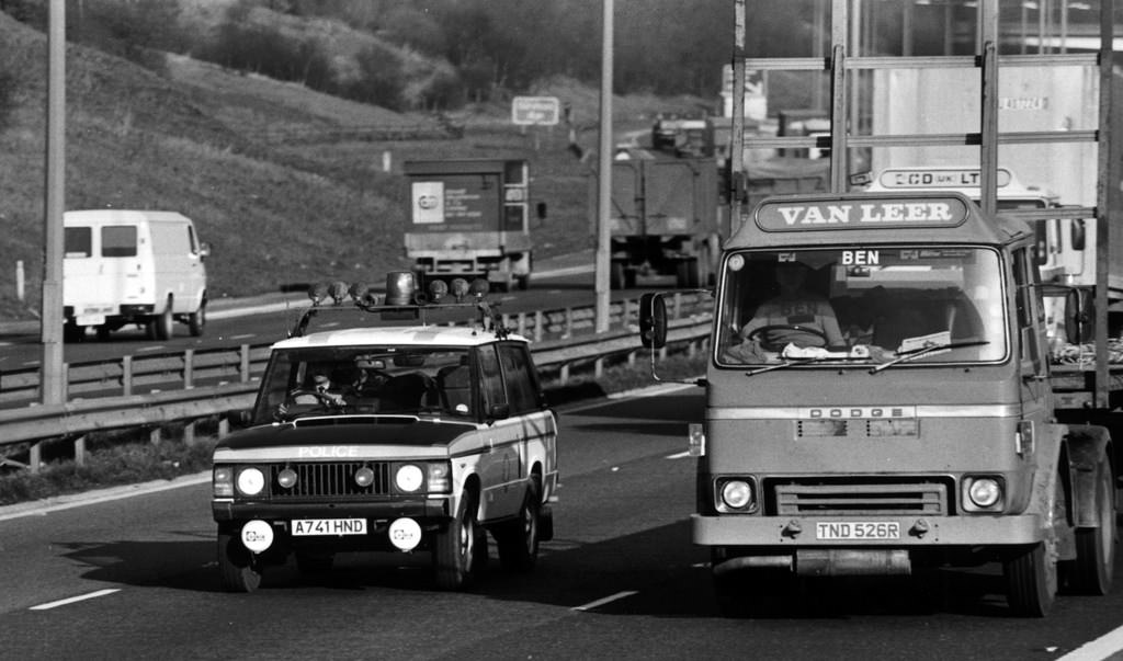A Range Rover of Greater Manchester Police's Motorway Unit overtakes a Dodge lorry while on patrol in 1984