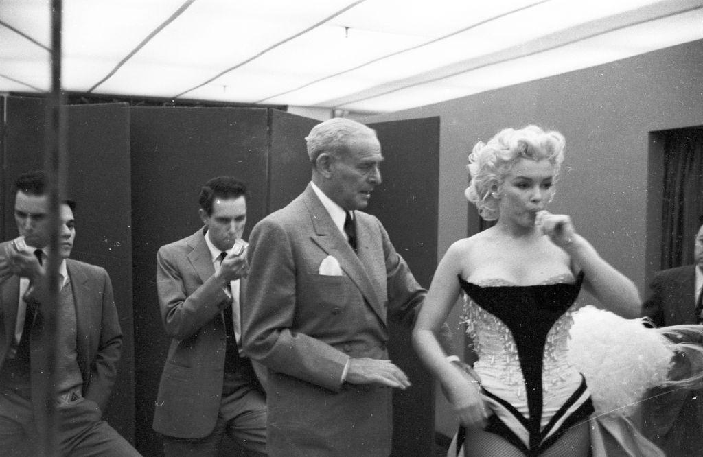 Marilyn Monroe gets fitted for her costume in a dressing room.