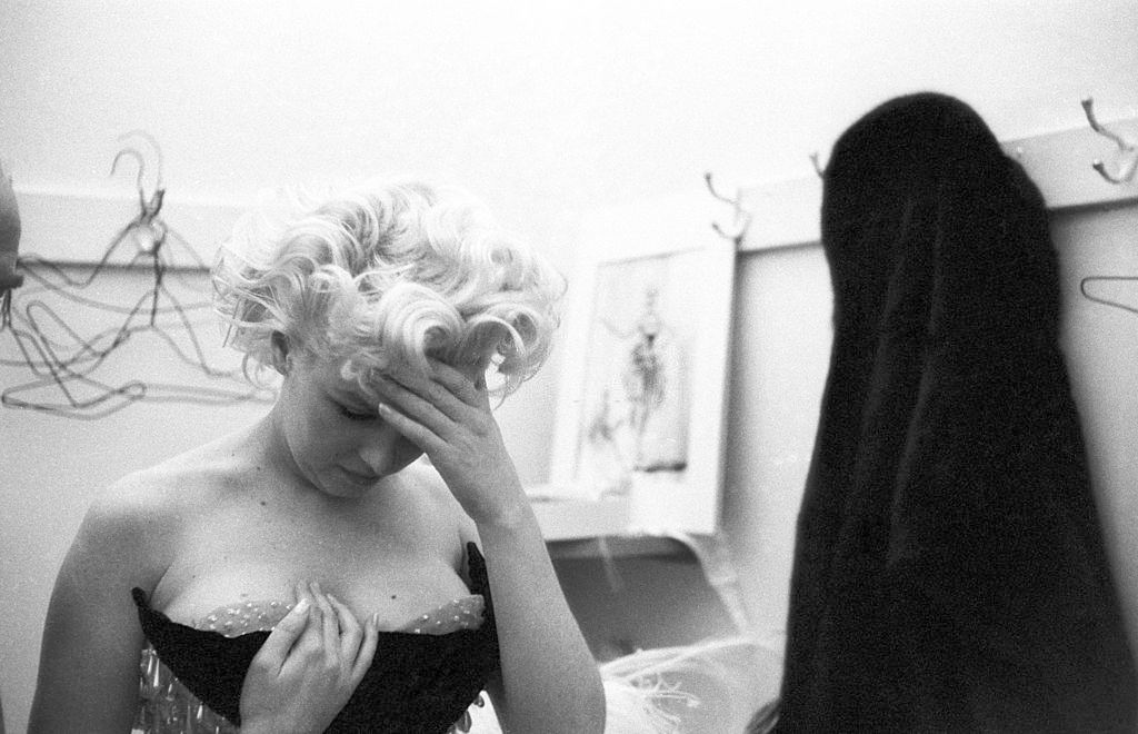 Marilyn Monroe wells up with tears of frustration because her costume doesn't fit right in a dressing room.