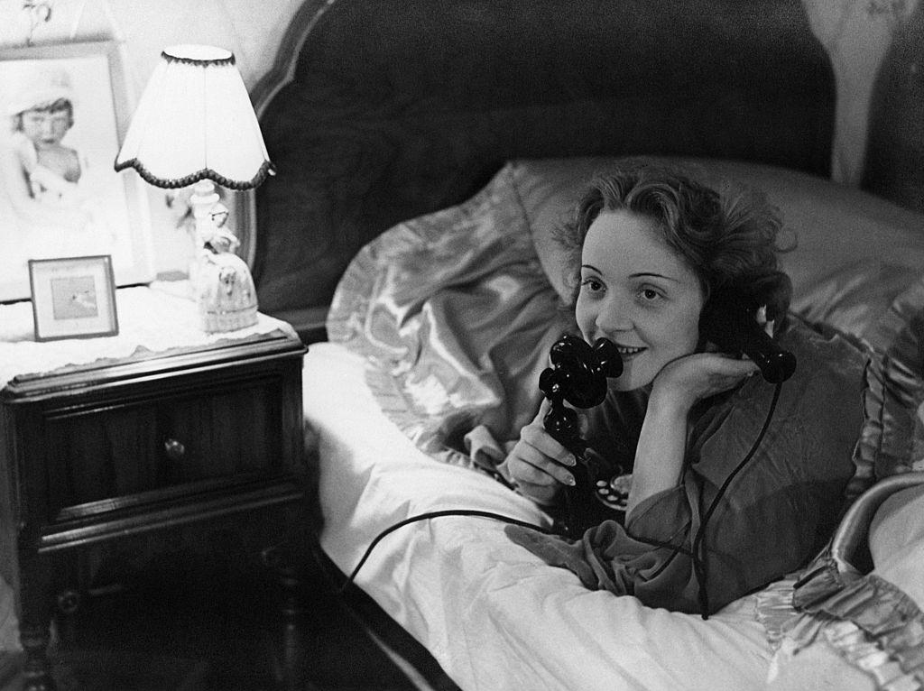 Marlene Dietrich making a telephone call to her daughter from her bed in Hollywood., 1930s