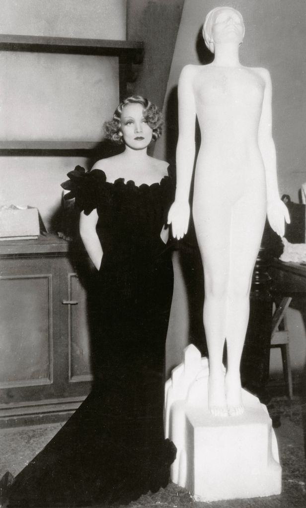 Marlene Dietrich with a statue created for her film in 1930s.
